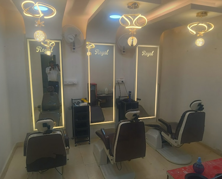 Barber chairs and illuminated mirrors inside Royal Men's Beauty Salon